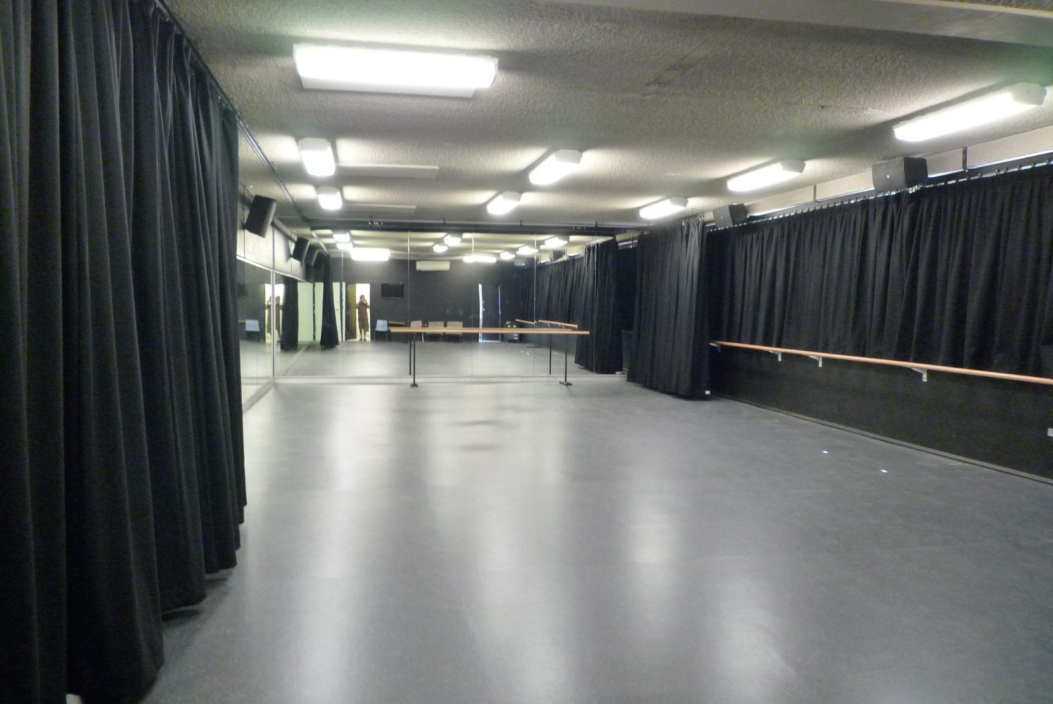 small studio maximising space with curtains, portable barres, mirrors and wall fixed barres